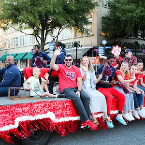 csu coaches and students on a parade float waving
