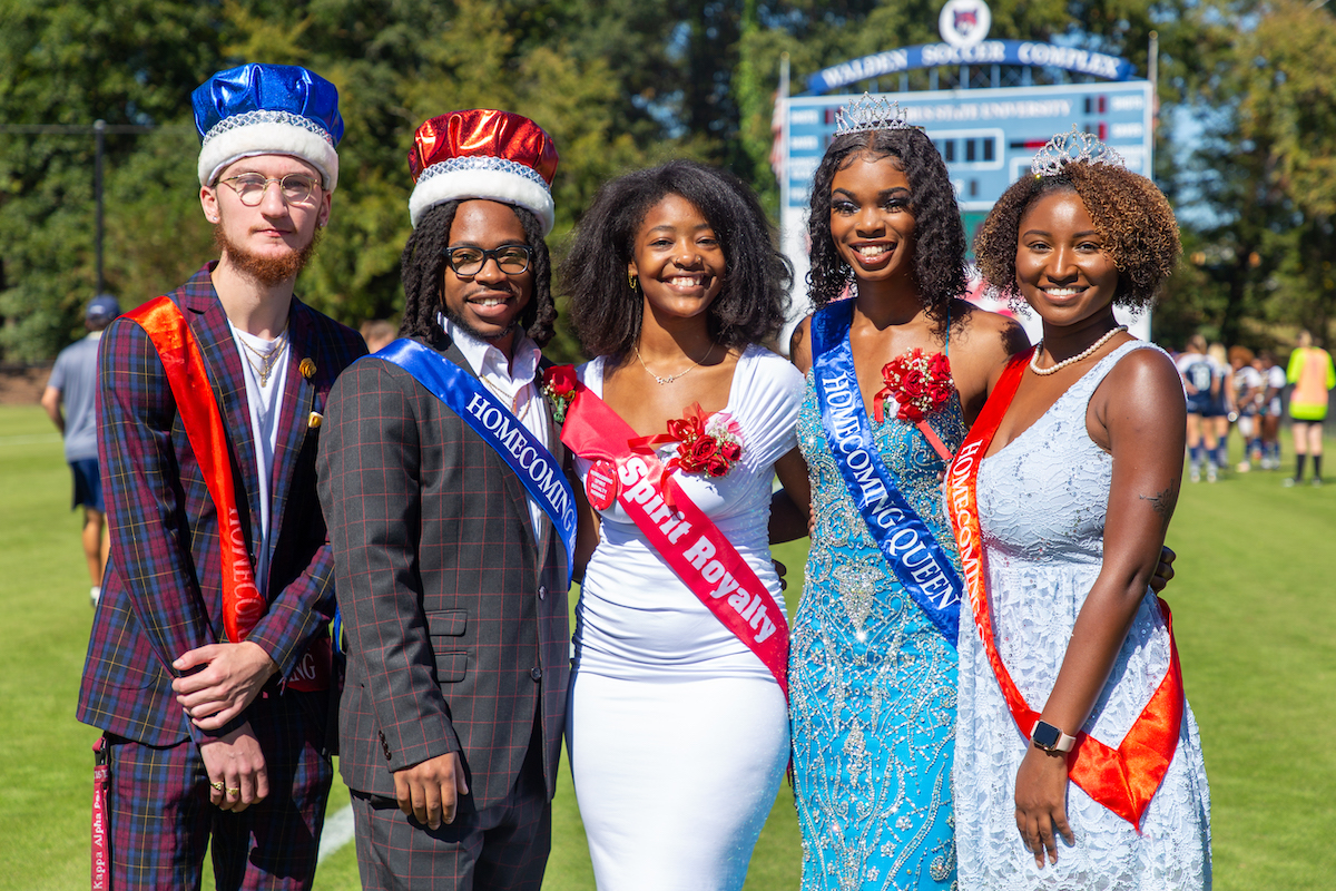 Two male and five female members of the Homecoming Court in formal wear, all wearing sashes